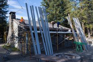 A U.S. Forest Service crew works to replace the nearly 30-year-old roof on the historic building of Skaters Cabin on Wednesday, Sept. 12, 2018. (Michael Penn | Juneau Empire)