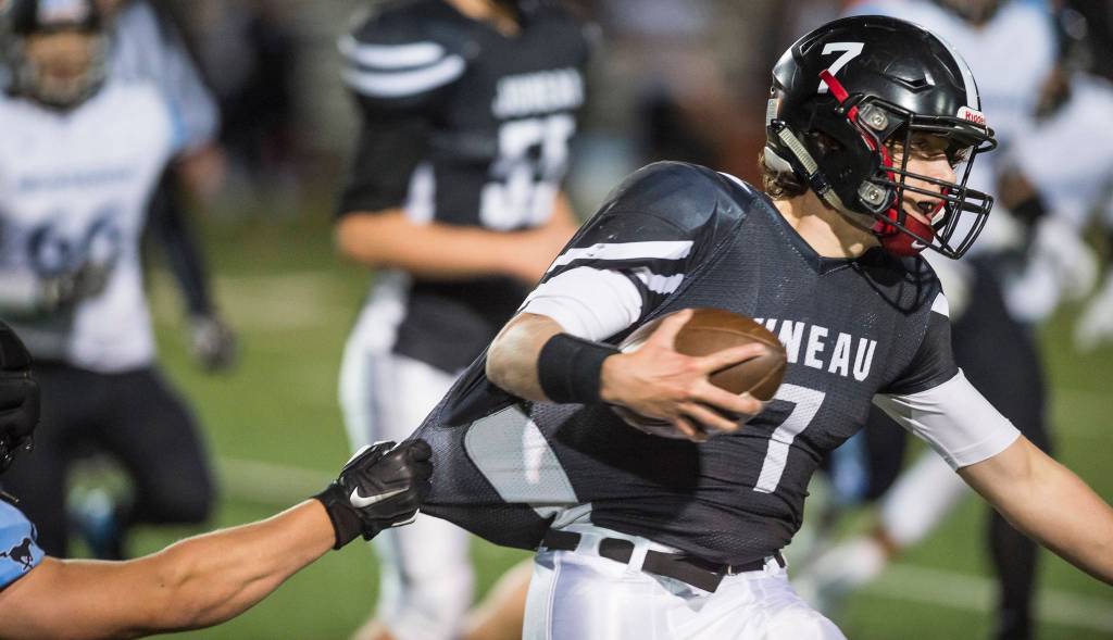 Juneau Uniteds quarterback Cooper Kriegmont is held onto by Chugiaks Torrin Girard at Adair-Kennedy Memorial Field on Friday, Sept. 14, 2018. Chugiak won 22-7. (Michael Penn | Juneau Empire)