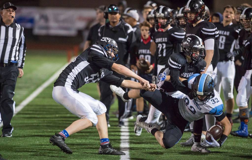 Juneau Uniteds Gaven Smith, left, and Hansel Hinckle push Chugiaks Christian Beesing out of play at Adair-Kennedy Memorial Field on Friday, Sept. 14, 2018. A penalty was called on the play. Chugiak won 22-7. (Michael Penn | Juneau Empire)