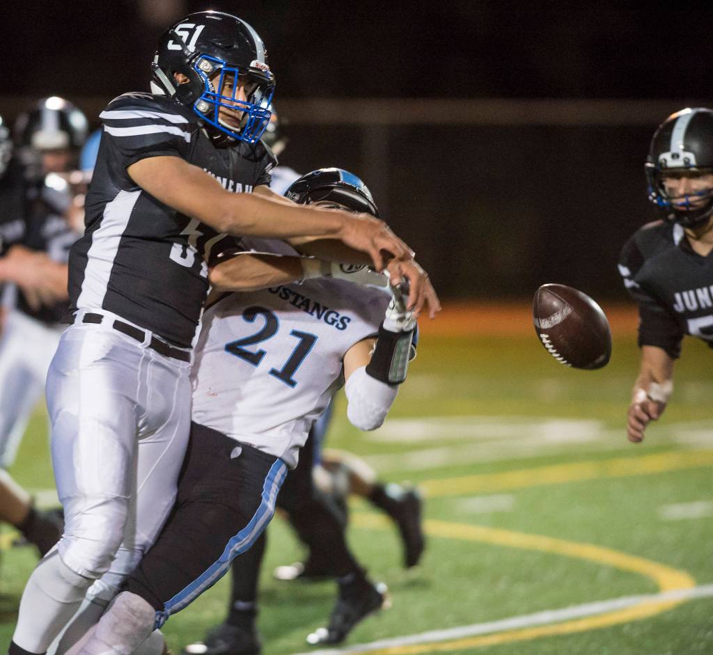 Juneau Uniteds William Skinna, left, knocks the ball away from Chugiaks Tyler Huffer at Adair-Kennedy Memorial Field on Friday, Sept. 14, 2018. Skinna recovered the ball on the play for a turnover. Chugiak won 22-7. (Michael Penn | Juneau Empire)