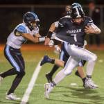 Juneau Uniteds Cooper Kriegmont, right, is slowed down by Chugiaks Brandon OFihelly at Adair-Kennedy Memorial Field on Friday, Sept. 14, 2018. Chugiak won 22-7. (Michael Penn | Juneau Empire)