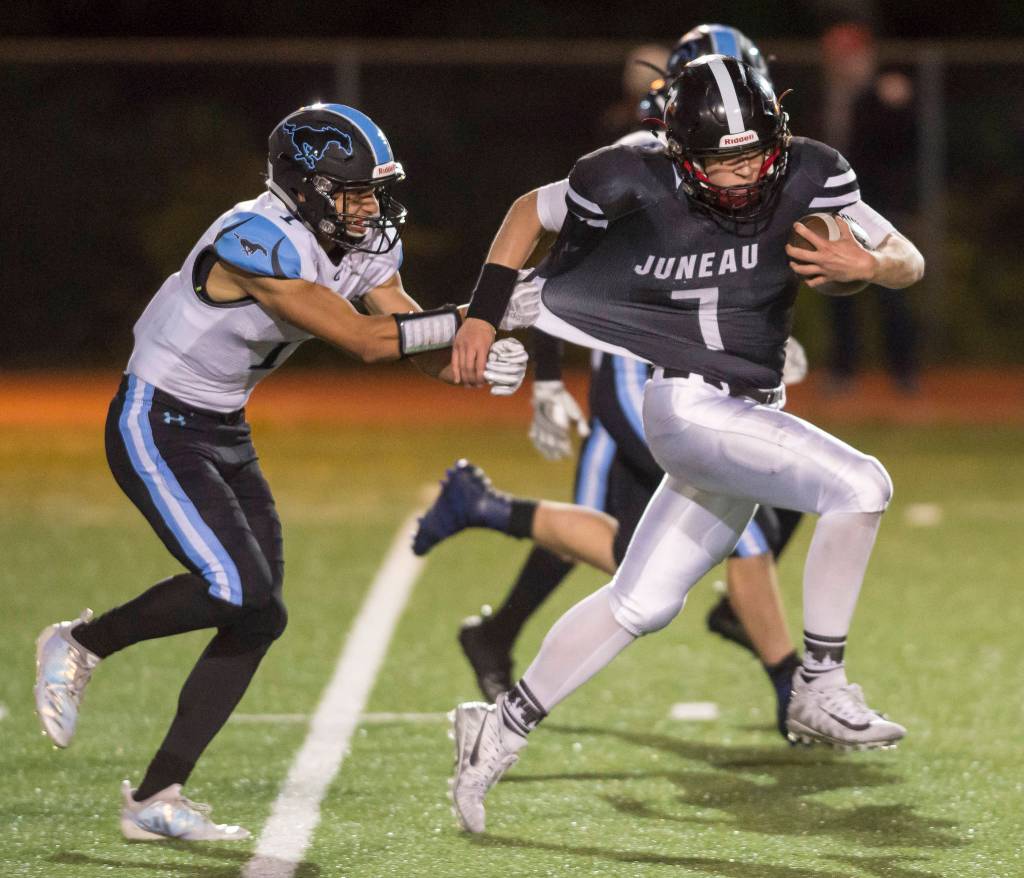 Juneau Uniteds Cooper Kriegmont, right, is slowed down by Chugiaks Brandon OFihelly at Adair-Kennedy Memorial Field on Friday, Sept. 14, 2018. Chugiak won 22-7. (Michael Penn | Juneau Empire)
