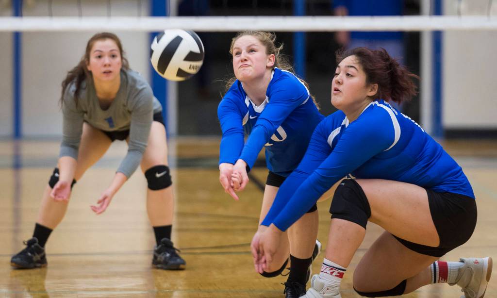 Thunder Mountains Audrey Welling, center, bumps the ball up against Ketchikan backed up by teammates Tasi Fenumiai, right, and Leilani Eshnaur at TMHS on Friday, Sept. 14, 2018. TMHS won 3-0. (Michael Penn | Juneau Empire)