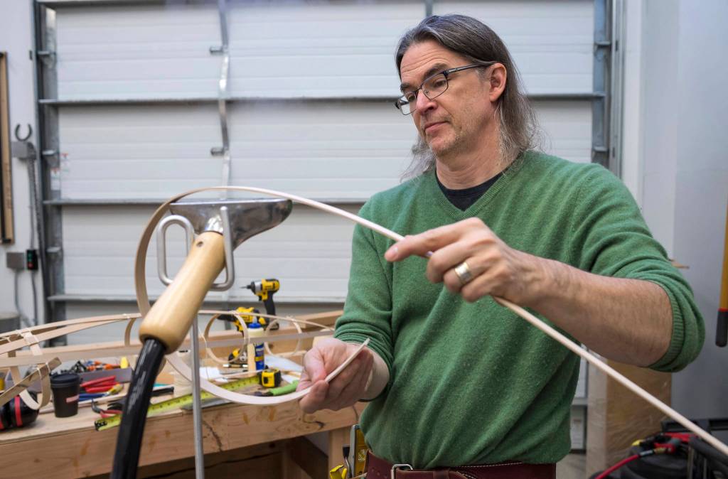 Exhibit Specialist Aaron Elmore steams a wooden piece as he builds one of the eight legs for a giant octopus for the Alaska State Museums childrens room on Monday, Sept. 17, 2018. (Michael Penn | Capital City Weekly)