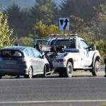 A damaged vehicle is pulled away by a tow truck after an afternoon car crash at the Fred Meyer intersection on Friday. (Michael Penn | Juneau Empire)