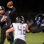 Juneau Uniteds quarterback Cooper Kriegmont passes against a rush by Colonys Isaac Richardson at Thunder Mountain High School on Friday, Sept. 21, 2018. (Michael Penn | Juneau Empire)