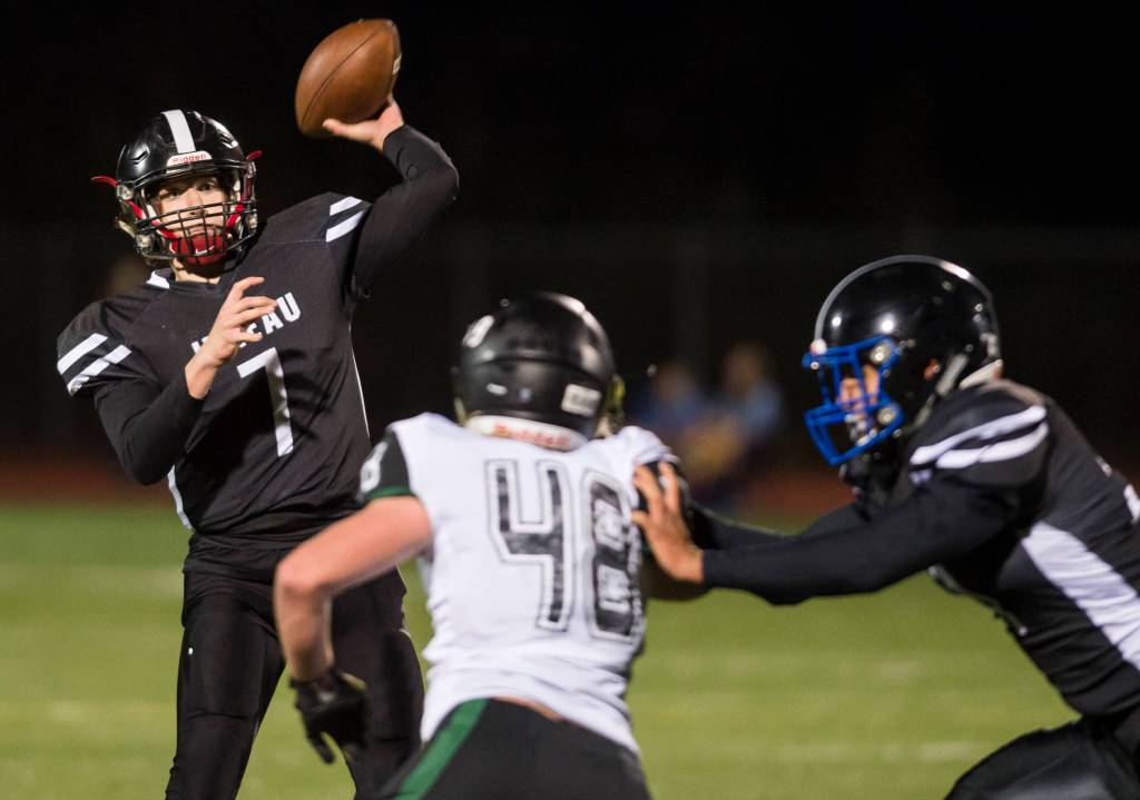 Juneau Uniteds quarterback Cooper Kriegmont passes against a rush by Colonys Isaac Richardson at Thunder Mountain High School on Friday, Sept. 21, 2018. (Michael Penn | Juneau Empire)