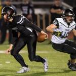 Juneau Uniteds quarterback Cooper Kriegmont, left, evades the rush of Colonys Isaac Richardson at Thunder Mountain High School on Friday, Sept. 21, 2018. (Michael Penn | Juneau Empire)