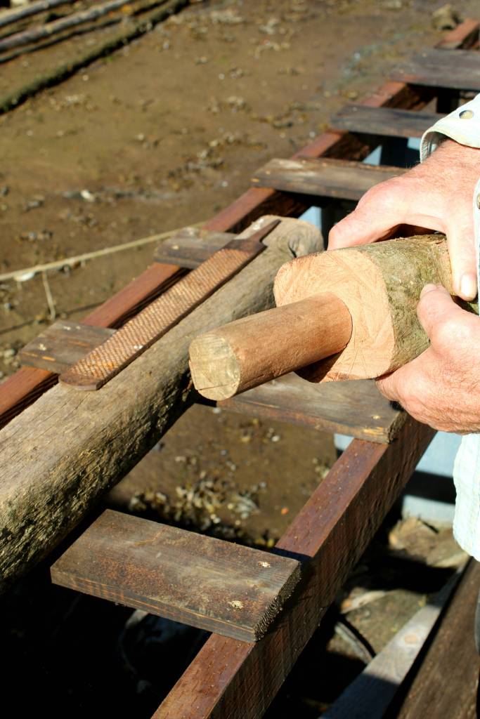 Gary Neilson inspects the tight grain of the ironbark splitting maul he made to cut cedar shakes. (Tara Neilson | For the Capital City Weekly)