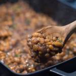 Erin Anais Heists prepares baked bean with a barbeque sauce made from high-bush cranberries on Friday, Sept. 21, 2018. (Michael Penn | Juneau Empire)