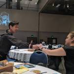 Ayyu Qassataq, Vice President for First Alaskans Institute passes a microphone to Adrianne Christensen of Port Heiden, who was in Juneau for a two-day social justice summit FAI hosted at Centennial Hall. (Ben Hohenstatt | Capital City Weekly)