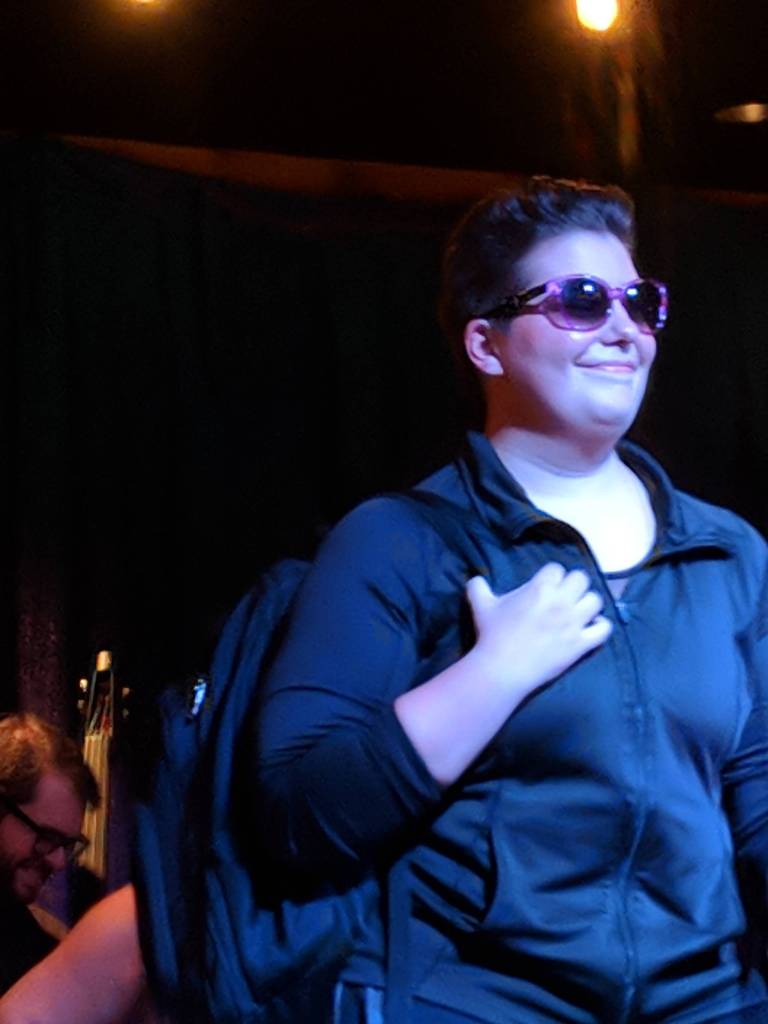 Kelsey Riker, performer for the Nude & Rude Revue burlesque troupe, began her performance with a just-off-the-bus look before shedding the backpack and more during a tap routine. (Ben Hohenstatt | Capital City Weekly)