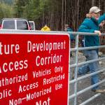 Alan Steffert, project manager for the city, closes the gate to the West Douglas Pioneer Road after a ribbon cutting ceremony to officially open the West Douglas Pioneer Road on Friday, Sept. 28, 2018. (Michael Penn | Juneau Empire)
