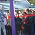 Children wait for Mayor Ken Koelsch to cut a ribbon at the entrance to Project Playground on Saturday at Twin Lakes. (Kevin Gullufsen | Juneau Empire)
