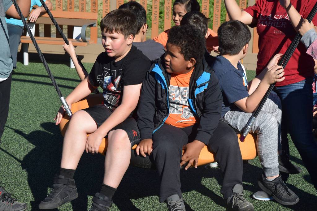 Kids test out some of the new play equipment on Saturday at Project Playground. (Kevin Gullufsen | Juneau Empire)