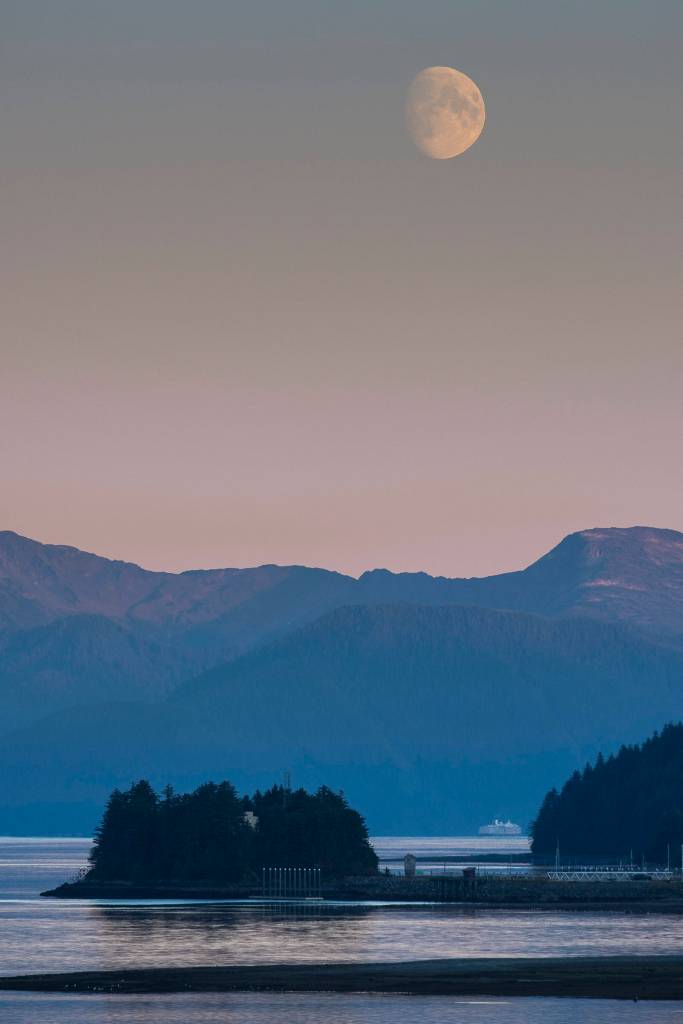 A cruise ship heads for Stephens Passage as the moon rises over the Coastal Mountain range on Thursday. (Michael Penn | Juneau Empire)