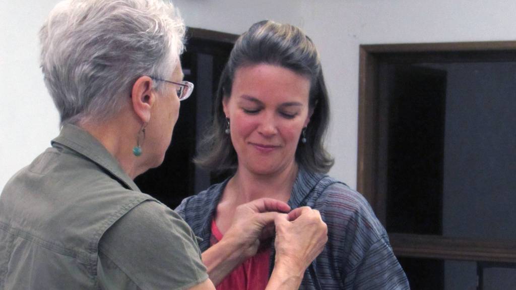 Toastmaster District Director Joanna DeSantos pins Valley Toastmasters Club President Jenn Berger with a Competent Communicator pin. Berger was one of three club members to earn the distinction during a Tuesday morning meeting. (Ben Hohenstatt | Capital City Weekly)