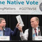 Former U.S. Sen. Mark Begich, left, and Gov. Bill Walker pass Mike Dunleavys name plate during a Special Native Issues Forum for governor candidates at the Elizabeth Peratrovich Hall on Tuesday, Oct. 2, 2018. Libertarian candidate Billy Toien, out of picture to the left, requested the name plate. Dunleavy did not attend the forum. (Michael Penn | Juneau Empire)
