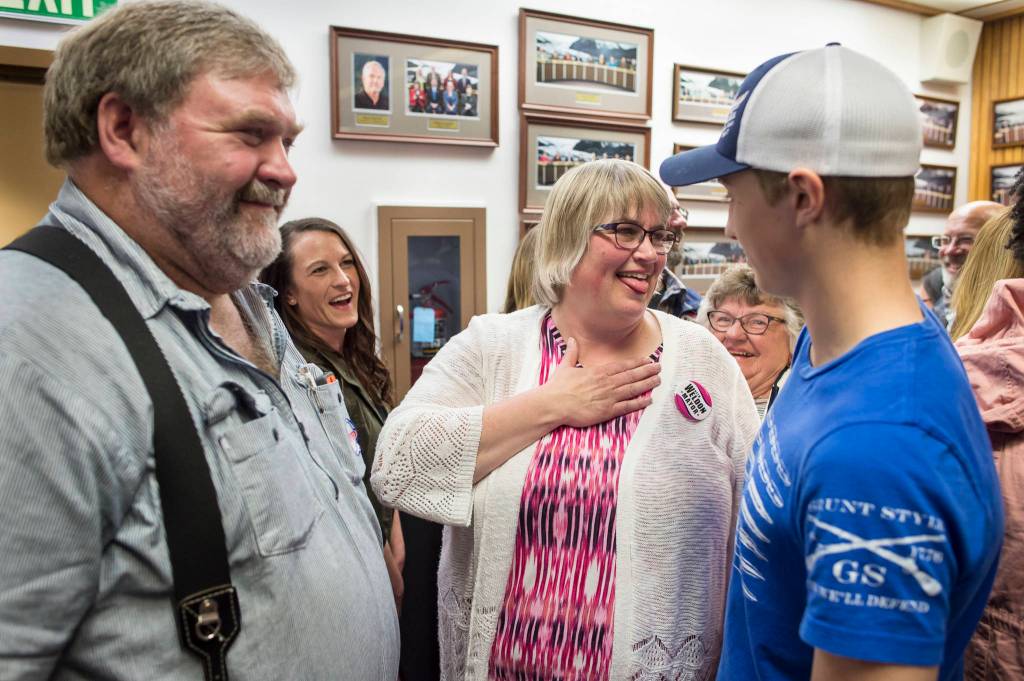 Mayor-elect Beth Weldon takes a breath after watching Election results with her husband, Greg, left, and son, Tyler, right, at the Assembly chambers on Tuesday, Oct. 2, 2018. (Michael Penn | Juneau Empire)