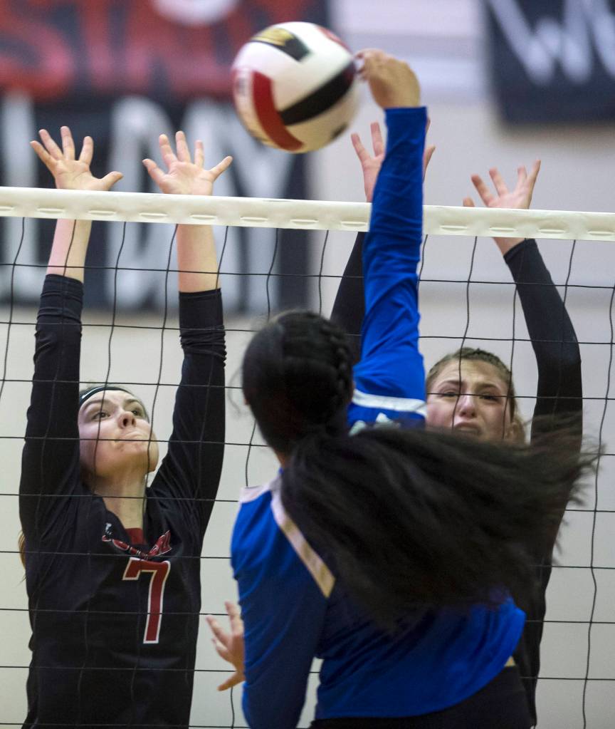 Juneau-Douglas Riley Stadt, left, and JoJo Griggs attempt to block Thunder Mountains Mariah Tanuvasa-Tuvaifale at JDHS on Friday, Oct. 5, 2018. (Michael Penn | Juneau Empire)