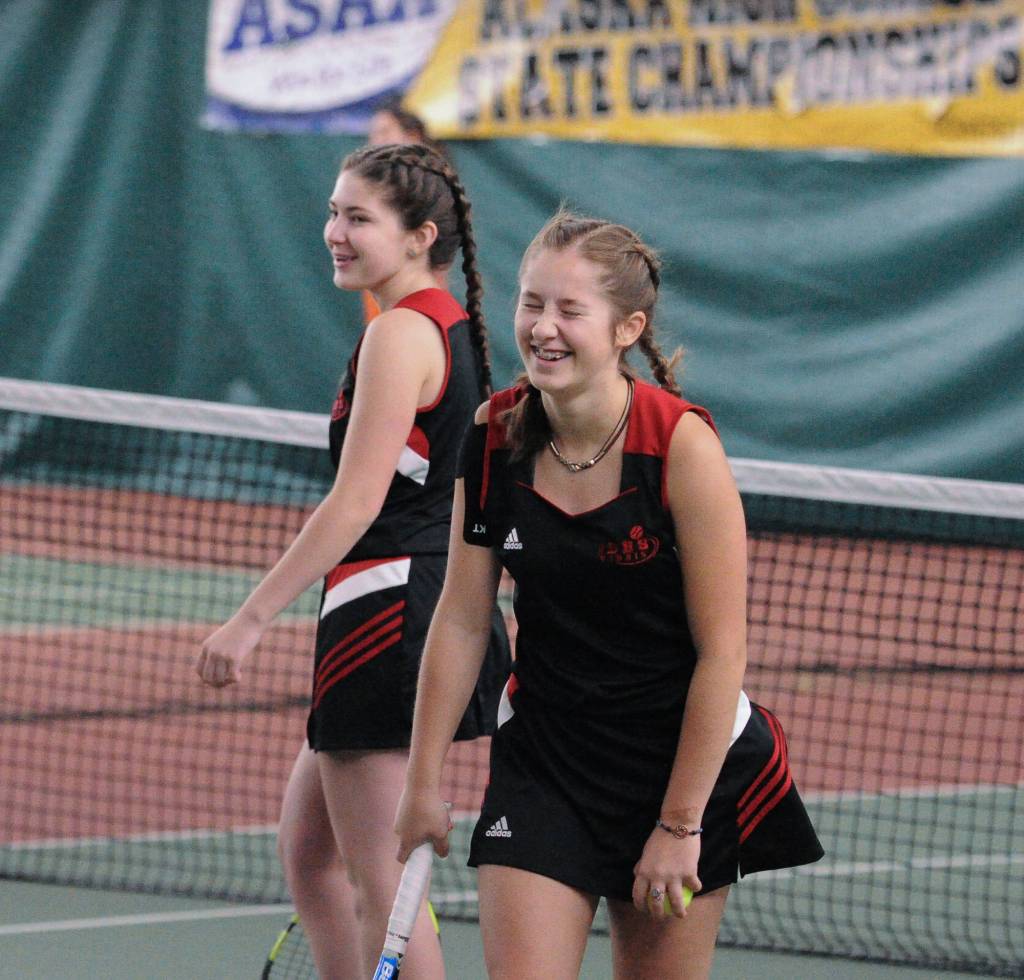 Adelie McMillan, foreground, and Olivia Moore find some humor against West Anchorage in the first round of the ASAA/First National Bank Alaska State Tennis Championships at the Alaska Club East in Anchorage on Friday, Oct. 5, 2018. (Michael Dinneen | For the Juneau Empire)
