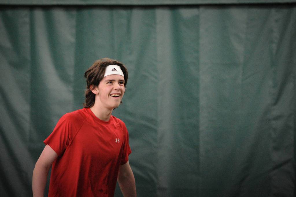 William Smoker smiles at the gallery after a great return against West Anchorage in the first round of the ASAA/First National Bank Alaska State Tennis Championships at the Alaska Club East in Anchorage on Friday, Oct. 5, 2018. (Michael Dinneen | For the Juneau Empire)
