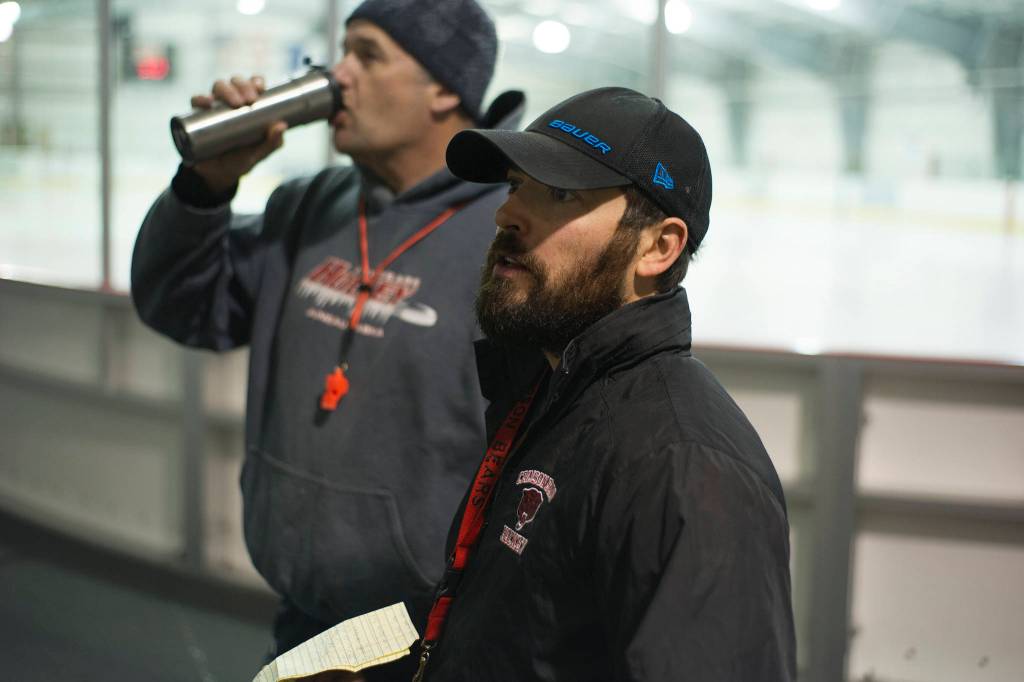 Juneau-Douglas High School hockey coaches Luke Adams, front, and Jay Lloyd, get ready for the first practice of the season on Wednesday morning at Treadwell Arena. The team practices at 6 a.m. three times a week. (Nolin Ainsworth | Juneau Empire)