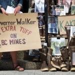 In this file photo from 2015, a protester stands next to rubber boots on the steps of the Alaska State Capitol during a rally to bring attention to the long-term protection of transboundary waters, principally the Taku, Stikine and Unuk watersheds. (Michael Penn | Juneau Empire)