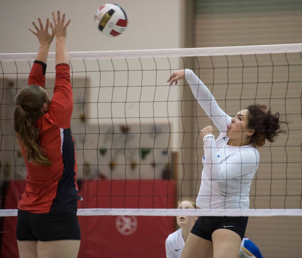 Thunder Mountains Letasiilemilion Fenumiai, right, spikes the ball against Juneau-Douglas Shaylin Cesar during the JIVE Tournament at Juneau-Douglas High School on Friday, Oct. 12, 2018, (Michael Penn | Juneau Empire)