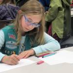Farrah Fremlin, 8, said she finds coloring calming during a How to Make a Monster workshop with artist Glo Rameriz Saturday afternoon at Douglas Public Library. (Ben Hohenstatt | Capital City Weekly)