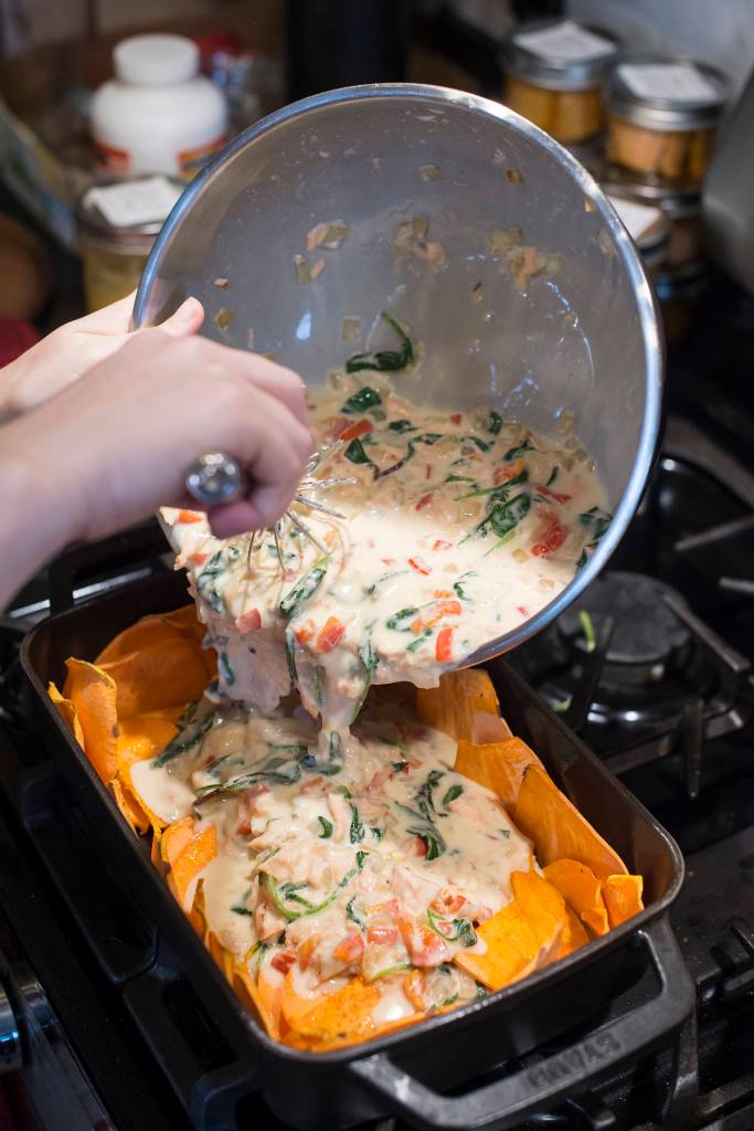 Erin Anais Heist pours a quiche mixture of egg, onion, red pepper, greens and coho salmon into a sweet potato crust in her home kitchen on Thursday, Oct. 4, 2018. (Michael Penn | Juneau Empire)