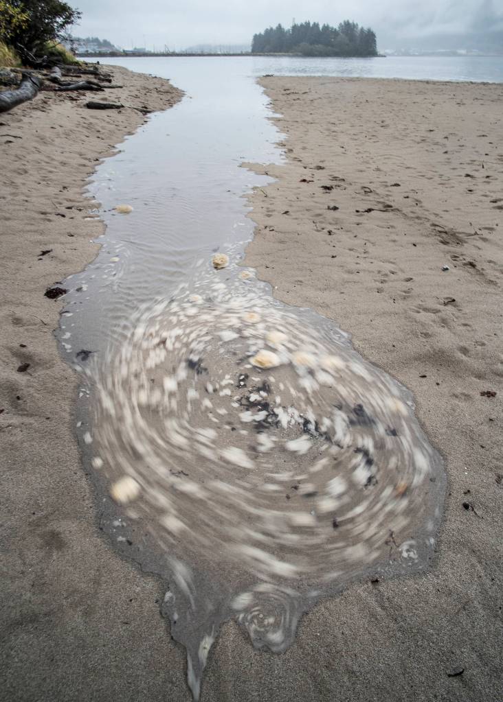 Foam on the incoming tide swirls at Sandy Beach on Thursday, Oct. 11, 2018. (Michael Penn | Juneau Empire)