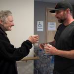 Trevor Kellar, a community navigator for St. Vincent de Paul, offers Sheila Robinson a cup of coffee on Friday, July 20, 2018. (Michael Penn | Juneau Empire)