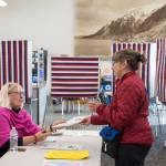 Election official Jacqueline Fowler, left, hands Becky Dierking her ballot in the Municipal Election at the Auke Bay Ferry Terminal on Tuesday, Oct. 2, 2018. (Michael Penn | Juneau Empire)