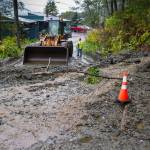 City maintenance crew waits for equipment to clean up a small mud slide at the south end of Gastineau Avenue on Monday, Oct. 15, 2018. (Michael Penn | Juneau Empire)