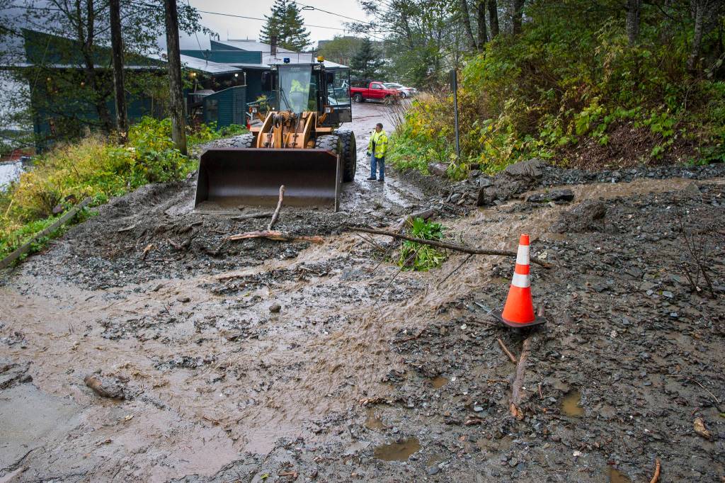 City maintenance crew waits for equipment to clean up a small mud slide at the south end of Gastineau Avenue on Monday, Oct. 15, 2018. (Michael Penn | Juneau Empire)