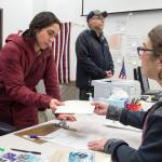 Libby Bakalar, left, receives her ballot from election official Tami Burgett, right, as Michael Grubbs waits during early voting at the State Office Building on Monday, Oct. 22, 2018. Voting is on the 8th floor of the State Office Building from 8 a.m.-5 p.m., Monday-Friday. The Elections Office in the Mendenhall Mall Annex is also open for voting during the same times plus Saturday, Nov. 3, 10 a.m.-4 p.m., and Sunday, Nov. 4, noon-4 p.m. (Michael Penn | Juneau Empire)