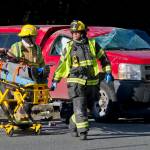 Capital City Fire/Rescue personnel wheel a man to a waiting ambulance at the scene of a two-car accident near the Egan Drive and Mendenhall Loop Road intersection in the Mendenhall Valley in March 2016. Two people were treated at Bartlett Regional Hospital for minor injuries. (Michael Penn | Juneau Empire File)