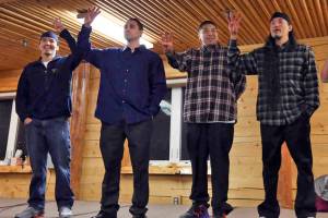 The Fairbanks Four  Marvin Roberts, left to right, Kevin Pease, Eugene Vent, and George Frese  hold up four fingers, symbolizing the Fairbanks Four, in the David Salmon Tribal Hall after they were freed in December 2015 in Fairbanks. (Rachel DOro | The Associated Press file)