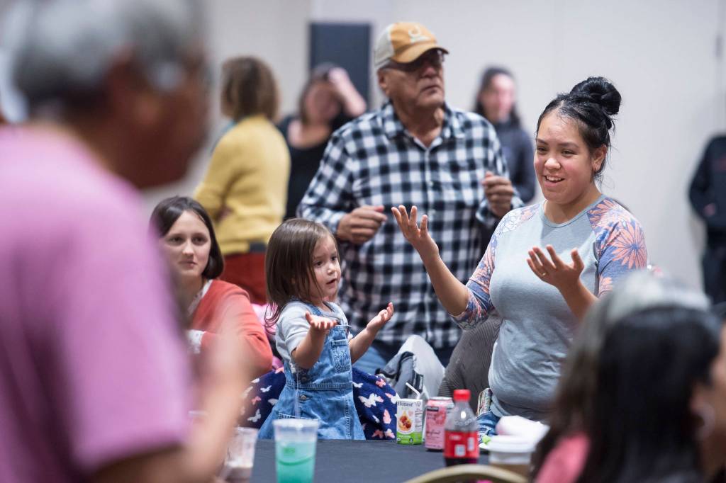 Sophie Parkin pays tribute to the Woosh.ji.een Dance Group as they perform during a Celebrate Survivors gathering sponsored by Central Council Tlingit and Haida Indian Tribes of Alaska and AWARE in the Elizabeth Peratrovich Hall on Tuesday, Oct. 23, 2018. October is Domestic Violence Awareness Month. (Michael Penn | Juneau Empire)