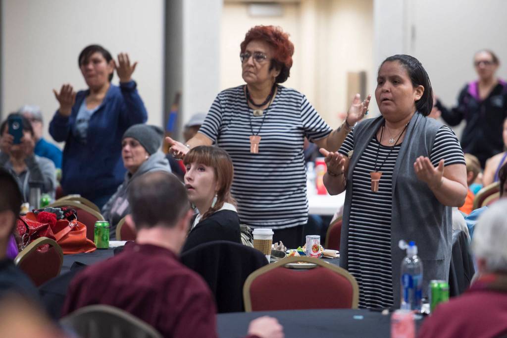 People pay tribute to the Woosh.ji.een Dance Group as they perform during a Celebrate Survivors gathering sponsored by Central Council Tlingit and Haida Indian Tribes of Alaska and AWARE in the Elizabeth Peratrovich Hall on Tuesday, Oct. 23, 2018. October is Domestic Violence Awareness Month. (Michael Penn | Juneau Empire)
