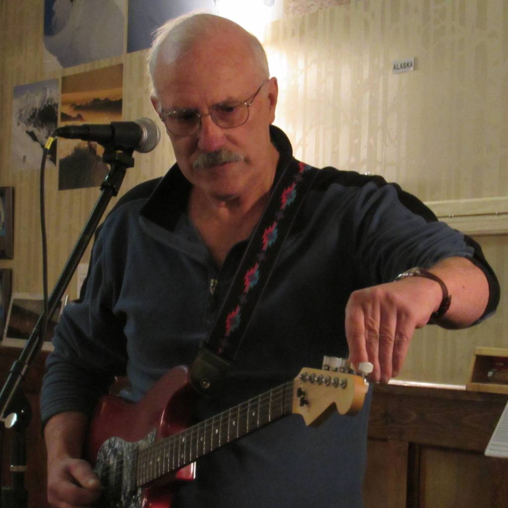 Philip Stewart tunes his electric guitar during the Mountainside Open Mic & Art Night at the Rookery. Stewart was the lone musician to play the electric guitar. (Ben Hohenstatt | Capital City Weekly)