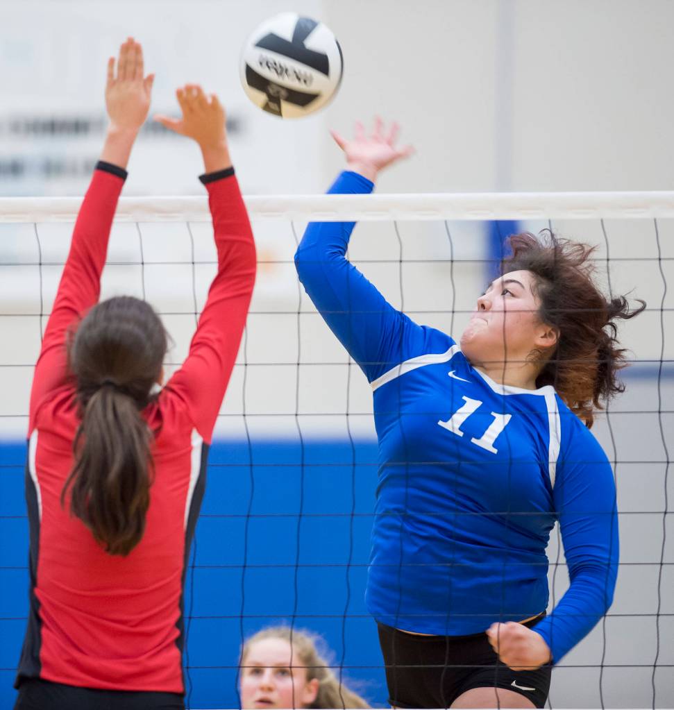 Thunder Mountains Tasi Fenumiai spikes the ball against Juneau-Douglas Jenae Pusich at TMHS on Friday, Oct. 26, 2018. (Michael Penn | Juneau Empire)