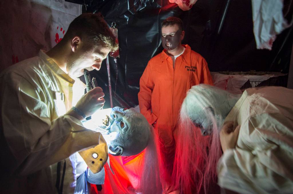 Anthonyu Hotka customizes his mask at the Haunted Station at the U.S. Coast Guards Station Juneau on Friday, Oct. 26, 2018. Station personnel pay for all the decoration themselves and take three weeks to ready the station. Entry is non perishable food items for the Southeast Alaska Food Bank. (Michael Penn | Juneau Empire)
