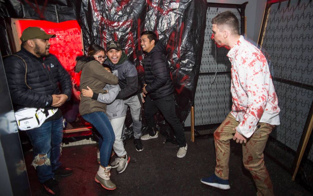 Juneau residents react to scares and chills as they make their way through the Haunted Station at the U.S. Coast Guards Station Juneau on Friday, Oct. 26, 2018. Station personnel pay for all the decoration themselves and take three weeks to ready the station. Entry is non perishable food items for the Southeast Alaska Food Bank. (Michael Penn | Juneau Empire)