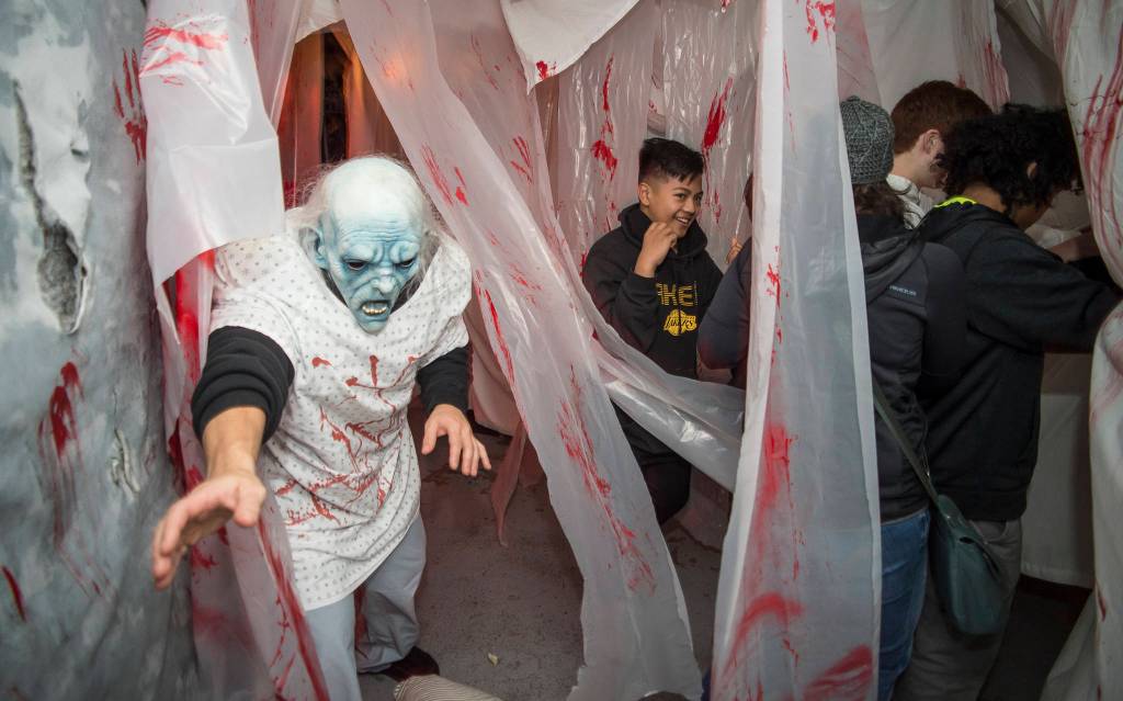 Juneau residents react to scares and chills as they make their way through the Haunted Station at the U.S. Coast Guards Station Juneau on Friday, Oct. 26, 2018. Station personnel pay for all the decoration themselves and take three weeks to ready the station. Entry is non perishable food items for the Southeast Alaska Food Bank. (Michael Penn | Juneau Empire)