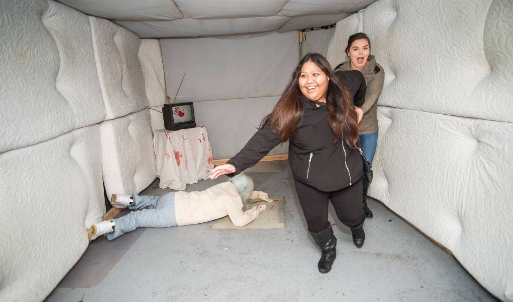 Juneau residents react to scares and chills as they make their way through the Haunted Station at the U.S. Coast Guards Station Juneau on Friday, Oct. 26, 2018. Station personnel pay for all the decoration themselves and take three weeks to ready the station. Entry is non perishable food items for the Southeast Alaska Food Bank. (Michael Penn | Juneau Empire)