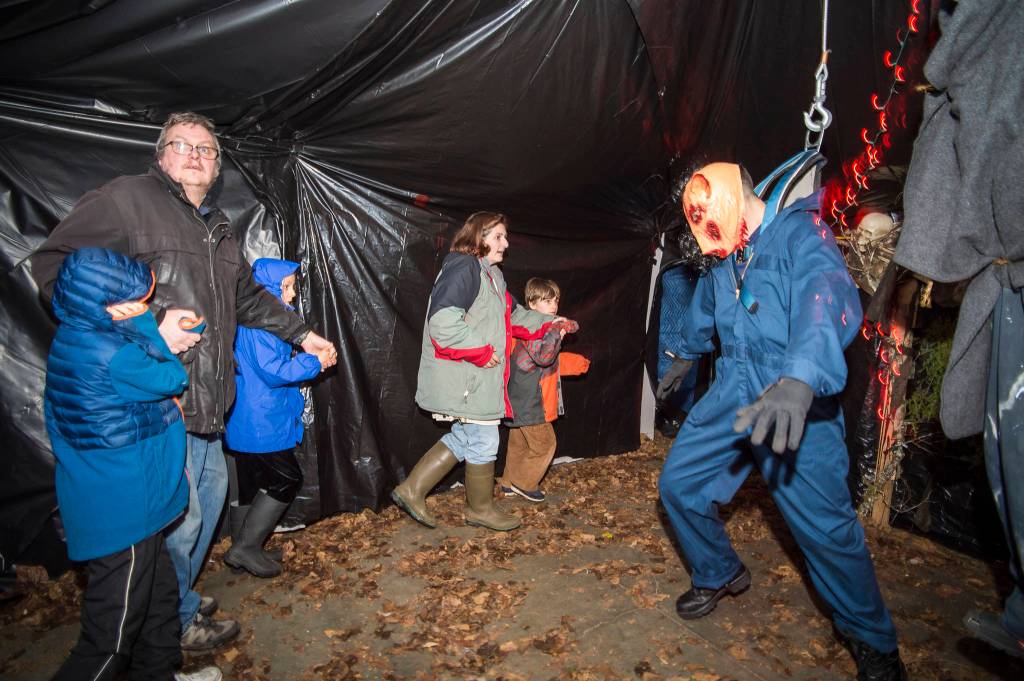 Juneau residents react to scares and chills as they make their way through the Haunted Station at the U.S. Coast Guards Station Juneau on Friday, Oct. 26, 2018. Station personnel pay for all the decoration themselves and take three weeks to ready the station. Entry is non perishable food items for the Southeast Alaska Food Bank. (Michael Penn | Juneau Empire)