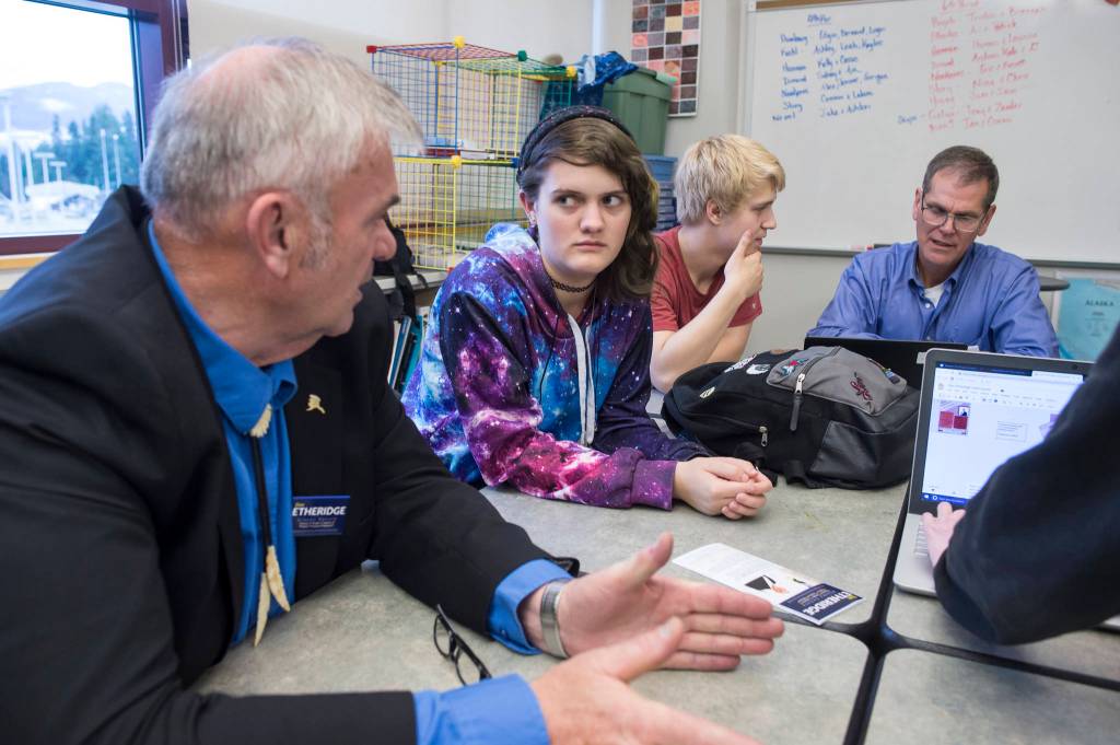 Senate District Q candidate Don Etheridge, left, and House District 34 candidate Jerry Nankervis, right, talk with Thunder Mountain High School senior students Arianna Csech, center, and Eric Sidney during their government class on Friday, Oct. 26, 2018. (Michael Penn | Juneau Empire)