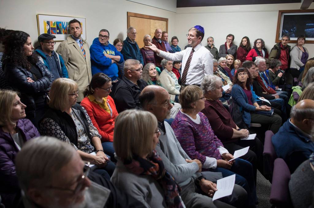 Congregation Sukkat Shalom member Jesse Kiehl makes his way through an overflowing audience asking for names of people to be remembered at Temple Sukkat Shalom on Tuesday, Oct. 30, 2018. The gathering at Temple Sukkat Shalom honored the memory of the 11 people killed by a gunman at the Tree of Life synagogue in Pittsburgh, Pennsylvania, on Saturday. (Michael Penn | Juneau Empire)